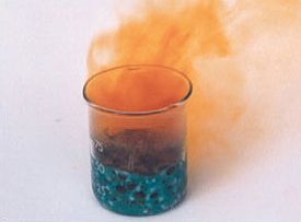 A beaker with a blue substance at the bottom emits orange smoke, creating a vivid display reminiscent of air pollution.